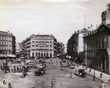 Céntrica y siempre bulliciosa, la Puerta del Sol se ha convertido en uno de los mayores emblemas de la ciudad. Lugar de encuentro de madrileños y visita obligada para todos los turistas. Su famoso reloj de la Casa de Correos (sede de la Comunidad de Madrid) marca las doce campanadas del nuevo año ante miles de personas que se congregan allí. Su historia comenzó con la construcción de la Casa de Correos a mediados del siglo XVIII. Un siglo más tarde, entre 1857 y 1862, la Puerta del Sol tomó su forma definitiva. Entre sus elementos ornamentales y edificios representativos principales se encuentra la placa del kilómetro cero, la estatua del Oso y el Madroño, su cartel del ‘Tío Pepe’ y la estatua ecuestre de Carlos III.