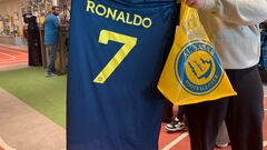 A fan holds t-shirt bearing the name Ronaldo and number 7, at the Saudi Al Nassr FC shop in the Saudi capital Ryadh, on December 31, 2022. - Cristiano Ronaldo on December 30 signed for Al Nassr of Saudi Arabia, the club announced, in a deal believed to be worth more than 200 million euros. The 37-year-old penned a contract which will take him to June 2025. (Photo by Fayez Nureldine / AFP)