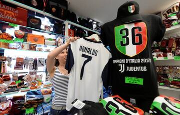 A woman adjusts a Juventus jersey with the name of Cristiano Ronaldo at a souvenir shop in Turin, Italy July 11, 2018.