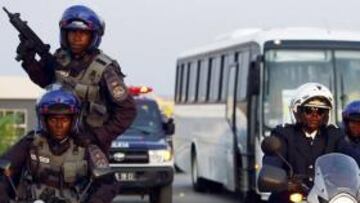 GRAN PRESENCIA POLICIAL. Un niño camina en presencia de un agente angoleño de las fuerzas especiales en las afueras de la Villa Olímpica, en la que están alojados los equipos que participan en el torneo en la provincia de Cabinda.