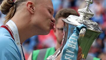 Manchester City's Norwegian striker Erling Haaland kisses the trophy after the English FA Cup final football match between Manchester City and Manchester United at Wembley stadium, in London, on June 3, 2023. (Photo by Adrian DENNIS / AFP) / NOT FOR MARKETING OR ADVERTISING USE / RESTRICTED TO EDITORIAL USE