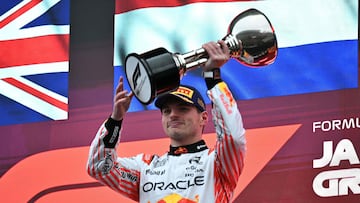 TOPSHOT - Red Bull Racing's Dutch driver Max Verstappen celebrates with his trophy on the podium after winning the Formula One Japanese Grand Prix at the Suzuka circuit in Suzuka, Mie prefecture, Japan on April 6, 2025. (Photo by Philip FONG / AFP)