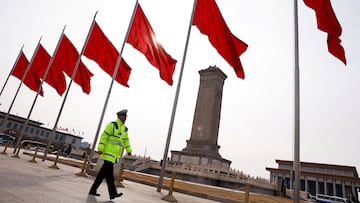 FILE PHOTO: A police officer walks past red flags, on the day of the opening session of the Chinese People's Political Consultative Conference (CPPCC), at Tiananmen Square, in Beijing, China March 4, 2024. REUTERS/Tingshu Wang/File Photo