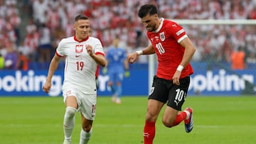 Poland's defender #19 Przemyslaw Frankowski fights for the ball with Austria's midfielder #10 Florian Grillitsch during the UEFA Euro 2024 Group D football match between Poland and Austria at the Olympiastadion in Berlin on June 21, 2024. (Photo by AXEL HEIMKEN / AFP)