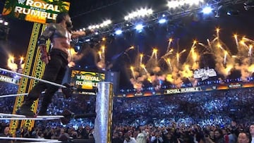 Roman Reigns señala el letrero de Wrestlemania después de ganar la Royal Rumble en Arabia Saudita.