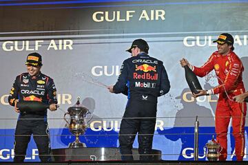 El primer clasificado, el piloto neerlandés de Red Bull Racing, Max Verstappen (C), el segundo clasificado, el piloto mexicano de Red Bull Racing, Sergio Pérez (L), y el tercer clasificado, el piloto español de Ferrari, Carlos Sainz Jr, celebran durante la ceremonia del podio.