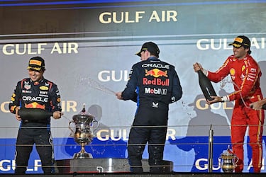 El primer clasificado, el piloto neerlandés de Red Bull Racing, Max Verstappen (C), el segundo clasificado, el piloto mexicano de Red Bull Racing, Sergio Pérez (L), y el tercer clasificado, el piloto español de Ferrari, Carlos Sainz Jr, celebran durante la ceremonia del podio.