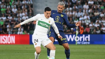 Elche's Chilean forward #24 Lucas Cepeda and Atletico Madrid's French forward #07 Antoine Griezmann fight for the ball during the Spanish league football match between Elche CF and Club Atletico Madrid at Martinez Valero Stadium in Elche on April 22, 2026. (Photo by JOSE JORDAN / AFP)