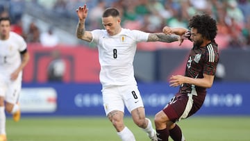 DENVER, COLORADO - JUNE 05: Nahitan Michel #8 of Uruguay advances the ball against Cesar Huerta #21 of Mexico during an international friendly match between Mexico and Uruguay at Empower Field At Mile High on June 05, 2024 in Denver, Colorado. Matthew Stockman/Getty Images/AFP (Photo by MATTHEW STOCKMAN / GETTY IMAGES NORTH AMERICA / Getty Images via AFP)