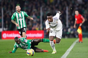 Youssouf Sabaly, tumbado sobre el césped, observa como Vinicius se va en carrera por la banda.