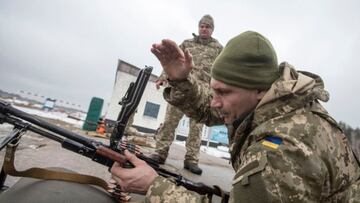 Vitali Kitschko, vestido con el uniforme del ejército ucraniano, mientras recarga su ametralladora ligera.