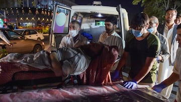 Volunteers and medical staff bring an injured man for treatment after two powerful explosions, which killed at least six people, outside the airport in Kabul on August 26, 2021. 