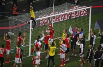 Los jugadores del  Benfica celebran sobre el terreno de juego su 33º título nacional, entrando en la historia del fútbol europeo. El equipo encarnado sumó los tres puntos de la jornada gracias a dos goles de Lima que le dejan a siete puntos de ventaja sobre el Sporting y a dieciocho del Oporto.