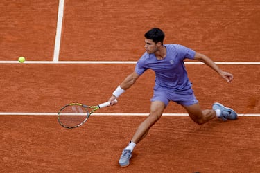 Alcaraz devuelve la pelota haciendo un estiramiento con el cuerpo para golpearla del revés.