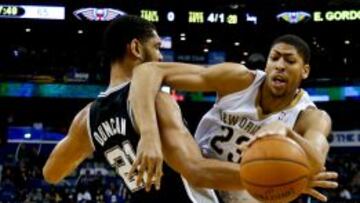 Anthony Davis (23) intenta llevarse la bola ante Tim Duncan (21).