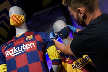 Ahora que la desescalada sigue su curso y se hace obligatorio el uso de mascarillas, es una buena ocasión para mostrar fidelidad al club de tus amores y estar protegido ante el COVID-19. Un empleado del Barça coloca unas mascarillas con los colores y el escudo blaugranas a unos maniquís en una tienda del club en Barcelona.