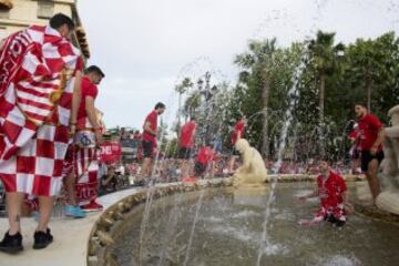 Los jugadores del Sevilla se bañan en la Fuente de Híspalis, en la plaza de la Puerta de Jerez, durante el paseo triunfal que ha realizado el equipo esta tarde para festejar y ofrecer a la ciudad su quinta Liga Europa conseguida el pasado miércoles en Basilea (Suiza)