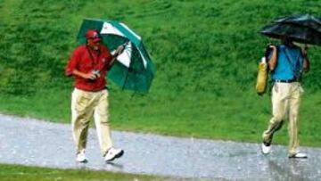 <b>BAJO LA LLUVIA. </b>Los jugadores se protegen del aguacero.