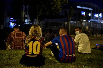 Los fans del Barça con camisetas del astro argentino y banderas se agrupan frente al Camp Nou. Estuvieron hasta la 1:00 AM (en la ciudad hay toque de queda por la covid-19).