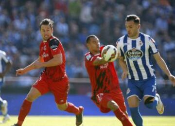 Lucas Pérez pelea un balón con los jugadores del Sevilla, Thimotée Kolodziejczak y Grzegorz Krychowiak.