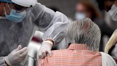 An elderly man is inoculated with the Oxford/AstraZeneca vaccine against COVID-19 amid the novel coronavirus pandemic, in Bogota on April 7, 2021. - Colombian President Ivan Duque on Sunday reinforced the curfews he recently imposed in the cities with the highest hospital occupancy to contain a new wave of covid-19 infections and deaths. (Photo by Raul ARBOLEDA / AFP)