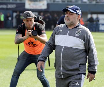 Argentine former football star and new team coach of Gimnasia y Esgrima La Plata Diego Armando Maradona  walks during their Argentina First Division Superliga football match against Racing Club, at El Bosque stadium, in La Plata city, Buenos Aires provinc