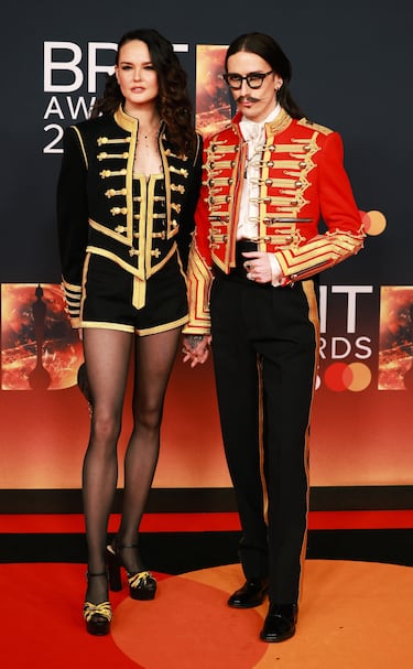 Lottie Kane y Joshua Kane posan en la alfombra roja. 