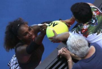  Serena Williams firma un autógrafo en una pelota de tenis gigante.