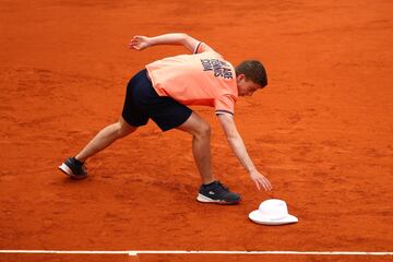 Uno de los recogepelotas recupera el sombrero caído a causa del fuerte viento en París. 