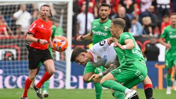SEVILLA, 04/05/2025.- El delantero del Sevilla Kike Salas (c) ante Diego, del Leganés, este domingo, durante el partido de la jornada 34 de LaLiga EA Sports, entre el Sevilla FC y el CD Leganés, en el estadio Ramón Sánchez Pizjúan de la capital andaluza. EFE/ Raúl Caro