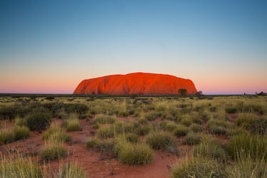 Uluru, también conocido como Ayers Rock, es el monolito de arenisca más famoso del mundo y el corazón espiritual de Australia, alzándose 348 metros sobre la llanura del desierto (aunque la mayor parte de su masa, unos 2.5 km, permanece oculta bajo tierra como un "iceberg" de piedra). Geológicamente, es un inselberg (monte isla) formado hace unos 550 millones de años a partir de sedimentos depositados en un antiguo abanico aluvial que, tras brutales movimientos tectónicos, fueron comprimidos y volcados casi verticalmente.