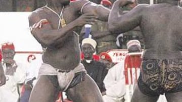 <b>UNA LUCHA RITUAL. </b>En la imagen grande, Ndao (izquierda) lucha con Yekini. En las fotografías pequeñas, un luchador con la imagen de su hechicero y el baño con tierra.