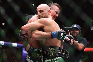Alexander Volkanovski de Australia y Diego Lopes de Brasil se abrazan tras el combate por el título de peso pluma durante el UFC 325.