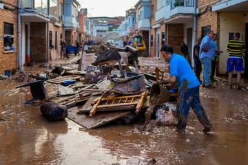 Un hombre limpia su casa afectada por las inundaciones en Utiel, España.