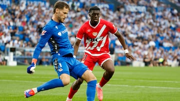 SAN SEBASTIÁN, 18/08/2024.- El portero de la Real Sociedad Alex Remiro (i) despeja el balón ante el delantero francés del Rayo Vallecano Randy Nteka durante el partido de LaLiga entre la Real Sociedad y el Rayo Vallecano, este domingo en el Reale Arena de San Sebastián. EFE/ Javier Etxezarreta
