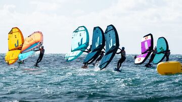 Varios riders se agarran a su cometa sobre su foil en la última parada del Spain Wing Foil Tour 2021 celebrado en Chiclana de la Frontera (Cádiz, España), el domingo 28 de noviembre.