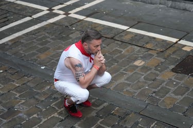 Un participante reza antes del primer encierro de los Sanfermines en Pamplona, ​​norte de España, el 7 de julio de 2025.