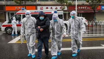 Imagen de varios profesionales sanitarios acompañando a un posible hombre contagiado por coronavirus en Wuhan.