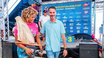 El concejal de Deportes de P&aacute;jara, Jos&eacute; Benito Alonso; y la campeona de la PWA, Sarah-Quita Offringa, ante el podio de la Fuerteventura World Cup. 