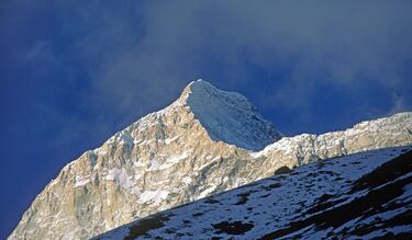 Una pirámide perfecta de hielo y roca que domina el horizonte. Fue conquistada en 1955 por una expedición francesa y sigue fascinando por su silueta geométrica.