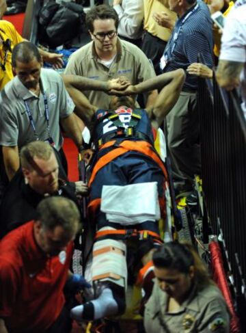 Paul George es trasladado en camilla después de sufrir una grave fractura de tibia y peroné en su pierna derecha.