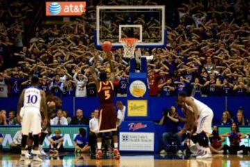 Los seguidores de Kansas Jayhawks intentan distraer al jugador de Iona Gaels, A.J. English, durante el partido de la liga universitaria en Lawrence, Kansas.