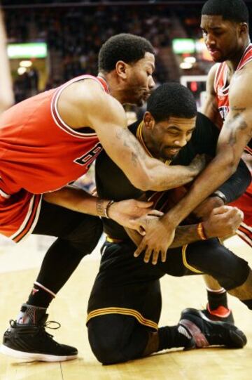 Derrick Rose y E'Twaun Moore luchan por la pelota con Kyrie Irving.