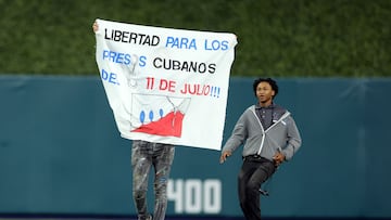 The man waved a banner demanding freedom for political prisoners in Cuba. He was immediately tackled by security and removed from the loanDepot Park stadium