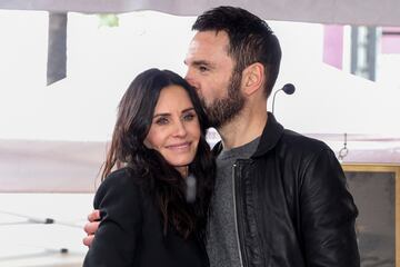 El músico Johnny McDaid besa cariñosamente a su pareja Courteney Cox durante la ceremonia de inauguración de la estrella de Cox en el Paseo de la Fama de Hollywood.