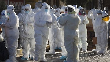 Vestidos con equipo de protección completo, los médicos se preparan para una nueva campaña de prueba de coronavirus casa por casa, en el barrio Villa Jaime Paz Zamora de El Alto, Bolivia, el sábado 4 de julio de 2020.
