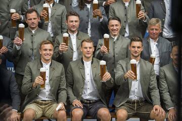 The players and coaches of Bayern Munich pose in Lederhosen and with beer in Munich, southern Germany, Sunday, Sept. 2, 2018 during a photo opportunity of a brewery ahead of the Oktoberfest. (Lino Mirgeler/dpa via AP)