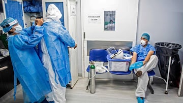 Health professionals put on protection gear before entering the Intensive Care Unit of the Alberto Sabogal Sologuren Hospital, in Lima, on July 02, 2020, amid the new coronavirus pandemic. (Photo by Ernesto BENAVIDES / AFP)