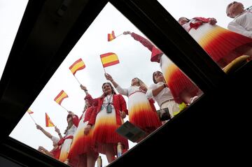 Atletas de la expedición española ondean la bandera de España dentro de la barcaza mientras recorre el rói Sena.