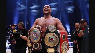 Tyson Fury posa con los tres cinturones de campeón de los pesos pesados.